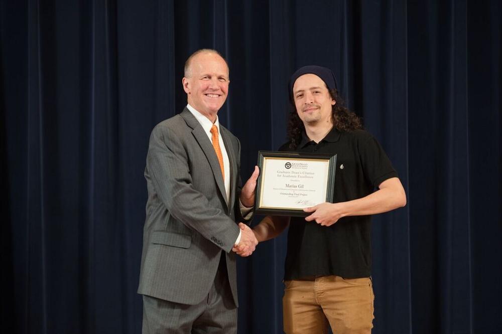 Doctor Potteiger posing for a photo with an award recipient in a black shirt and a beanie